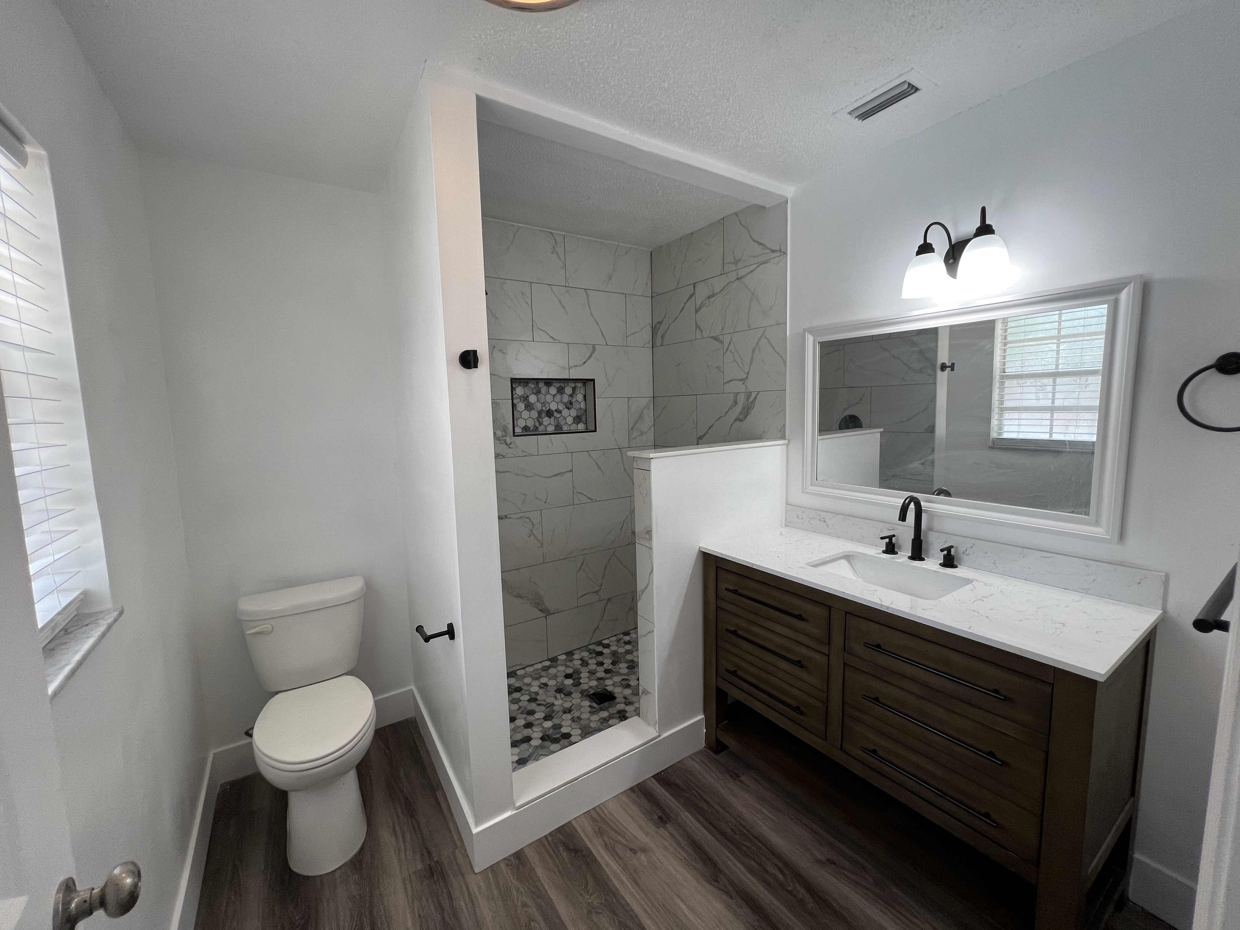 Master bath renovation with marble tile and walnut vanity